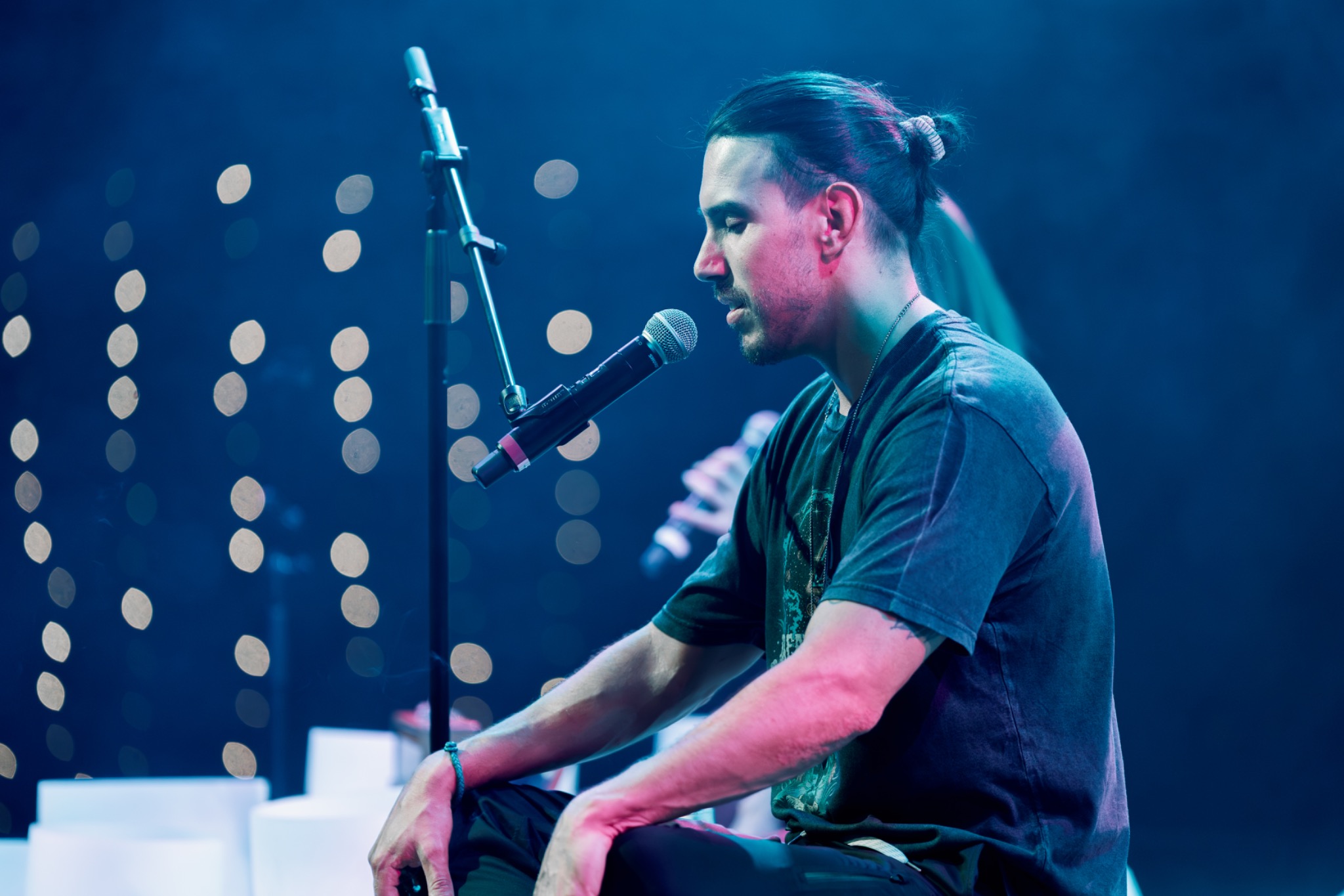 Portrait of Christopher August on stage facilitating a sonic breathwork journey